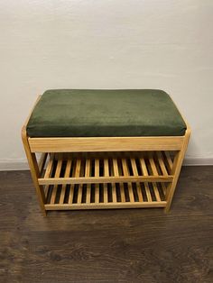 a wooden bench with a green cushion on it