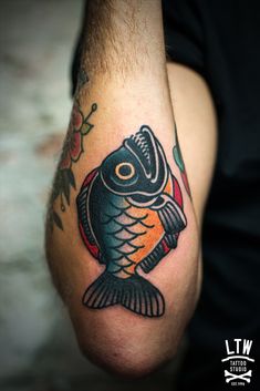 a man's arm with a fish tattoo on it