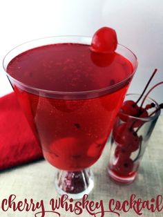 a red drink in a glass with cherries on the rim and text cherry whiskey cocktail