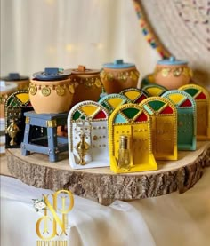 colorful wooden containers are sitting on top of a wood table with white cloth around them