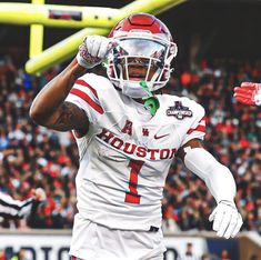 a football player is holding his hand up in the air while wearing a red and white uniform