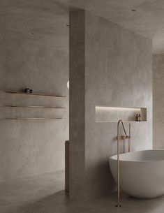 a large white bath tub sitting next to a tall wall in a room with concrete walls