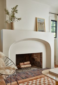 a living room with a fire place and rugs on the floor in front of it