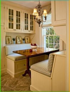 a kitchen with a table, bench and window in the corner next to an oven