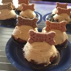 some cupcakes with white frosting and teddy bears on them are sitting on a blue plate