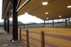 the inside of a barn with several stalls and lights on it's roof,