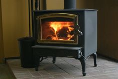 a wood burning stove sitting on top of a tiled floor