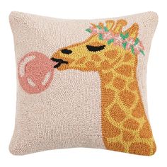 a pillow with a giraffe on it's face and a pink ball in its mouth