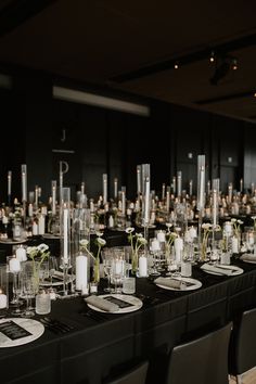 a long table is set with candles, flowers and vases for an elegant event