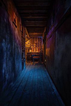 a dark hallway with wooden floors and walls