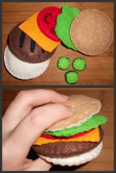 a hand is holding a hamburger made out of felt and some other things are on the table