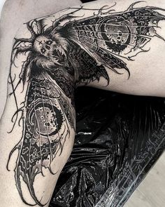 a woman's leg with tattoos on it and a butterfly sitting on top of her thigh