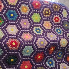 a purple quilt with colorful flowers on it