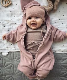 a baby in a bunny costume laying on top of a bed