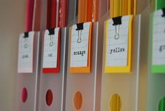 colorful file folders lined up on the wall with name tags attached to each file