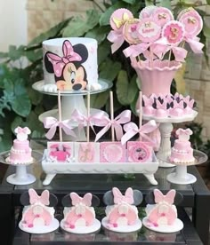 a table topped with lots of cakes and cupcakes