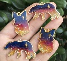 three enamel pins in the shape of animals with stars on them