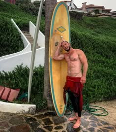 a man standing next to a yellow surfboard