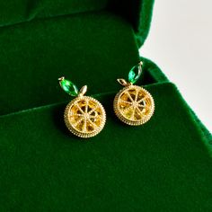 Add a playful pop of citrus to your style with these vibrant lemon-inspired stud earrings. Crafted in a golden finish, the intricate lemon slice design is paired with sparkling green crystal leaves for a fresh, fruity touch.  Perfect for adding a dash of fun to any outfit, these earrings are ideal for summer or whenever you want to brighten up your look. Lightweight and eye-catching, they bring a unique charm and cheerful elegance to your jewelry collection. * Dimensions: 10 x 15 mm | 0.4'' x 0. Stud Earrings Gold, Lemon Slice, Green Crystals, Earrings Sterling Silver, Everyday Jewelry, Unique Charms, Gold Earrings Studs, Jewelry Bags, Earrings Gold