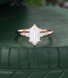 an emerald colored diamond ring sitting on top of a green tire