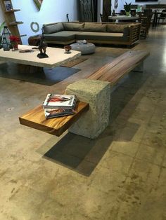 a wooden bench sitting in the middle of a living room next to a stone coffee table