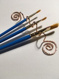 four pairs of scissors with spiral handles on white tablecloths and one pair of gold - plated metal hooks