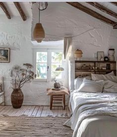 a bedroom with white walls and wooden floors