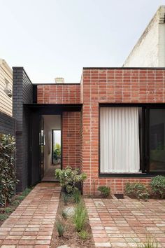 a brick house with an entry way leading to the front door and side yard area