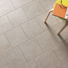 a table with a book on top of it in front of a tile flooring