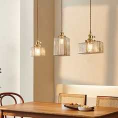 a dining room table with four lights hanging over it