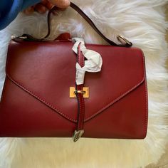 Burgundy Flat Leather: Top Leather Handle Bag With Gold Tone Hardware, Detachable Leather Shoulder Strap. Dual Interior Pocket, Single Zip Pocket At Center, Magnetic Closure At Front Flap, Protective Feet At Base. Height:8”Width:11”Depth:4”Handle Drop:10” Shoulder Strap:28” Top Handle Flap Bag For Errands, Crossbody Flap Bag For Shopping, Clutch Shoulder Bag With Top Carry Handle For Errands, Burgundy Handheld Bag, Handheld Satchel With Detachable Strap For Errands, Handheld Satchel For Errands With Detachable Strap, Burgundy Handheld Travel Bag, Burgundy Satchel Shoulder Bag With Gold-tone Hardware, Red Crossbody Flap Bag With Top Handle