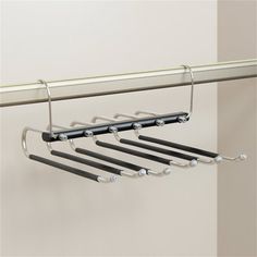 a metal rack with six black handles hanging from it