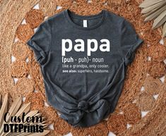 a t - shirt with the words papa on it sitting on top of a rug