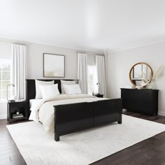 a bedroom with white walls and wood flooring has a large black bed in the middle