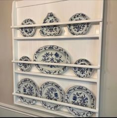 an old china cabinet with blue and white plates on it