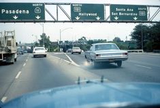 cars driving down the highway with signs above them