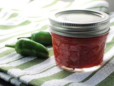 a jar filled with ketchup sitting on top of a green and white towel