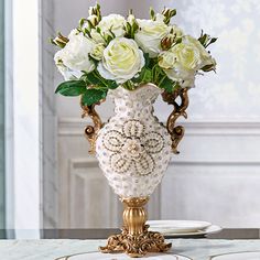 a vase with white flowers in it sitting on a table