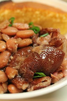 a white bowl filled with beans and meat