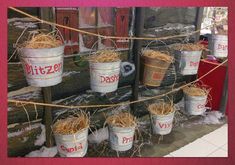 several buckets filled with straw sitting on top of a sidewalk