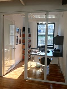 an office with sliding glass doors leading to a desk and bookshelf in the corner