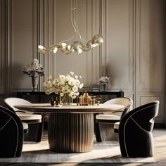 an elegant dining room with black chairs and a round marble table surrounded by white flowers