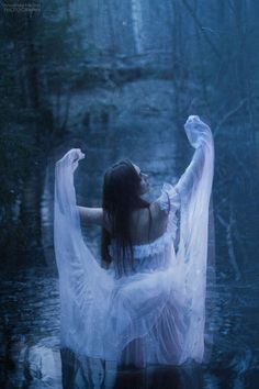 a woman in white dress standing in water