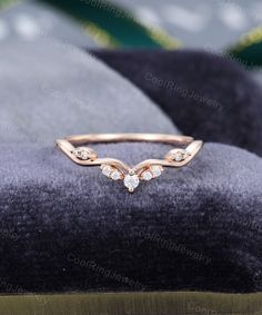 a close up view of a ring on top of a velvet cushion with diamonds in the middle