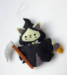 a stuffed animal that is holding a large hammer and wearing a witches costume on it's back