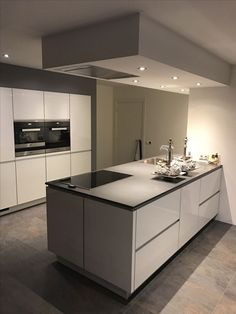 a modern kitchen with an island counter and white cabinets