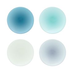 four different colored glass plates on a white surface