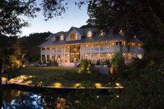 a large white house with lots of lights on it's front porch and side yard