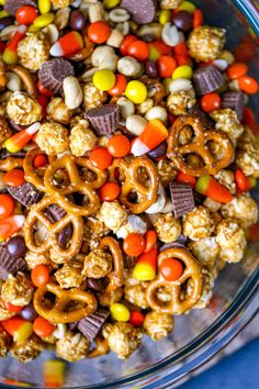 a bowl filled with candy corn and pretzels