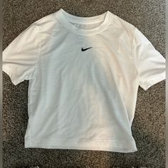 This White Nike Tee Is A Perfect Lightweight Cotton Material! It Has A Black Nike Check In The Middle, Is Slim Fitting, And Slightly Cropped. Never Worn! Nikey Mucle Shirts, White Crop Top Nike, Cheap Calvin Klein Short Sleeve T-shirt, Basic Nike Crew Neck Top, Nike Basic Tops For Spring, Basic White Nike Top, Nike Basic Summer Tops, Air Port, Tee Shirt Outfit